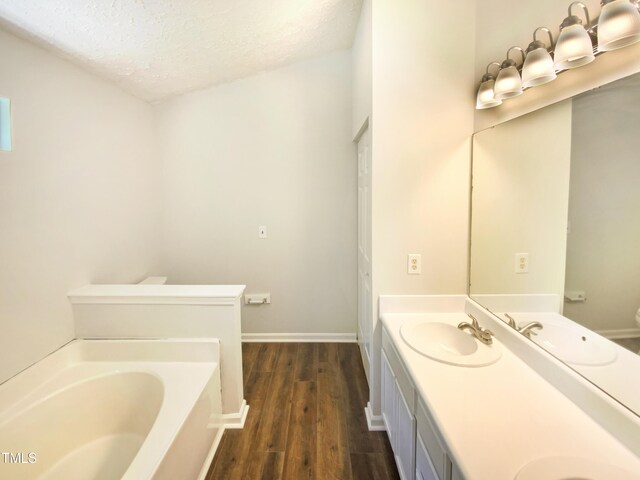 5828 Brambleton Ave, Raleigh, NC 27610 - full bathroom featuring wood finished floors, a textured ceiling, a garden tub, and a sink