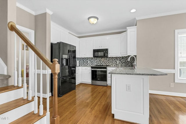 1454 Spring Pond Rd, Nashville, NC 27856 - kitchen featuring light wood-type flooring, a peninsula, white cabinets, black appliances, and a sink
