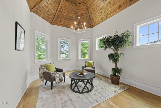 living area featuring wood ceiling, a chandelier, wood finished floors, baseboards, and high vaulted ceiling