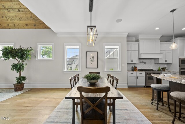 dining area with crown molding, recessed lighting, light wood-style flooring, and baseboards