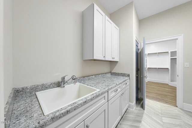 washroom featuring a sink and baseboards