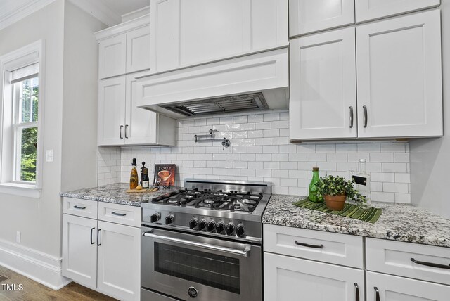 kitchen featuring high end stainless steel range, ornamental molding, white cabinets, backsplash, and light stone countertops