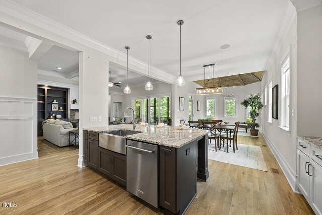kitchen with dishwasher, a sink, light wood-style floors, hanging light fixtures, and crown molding