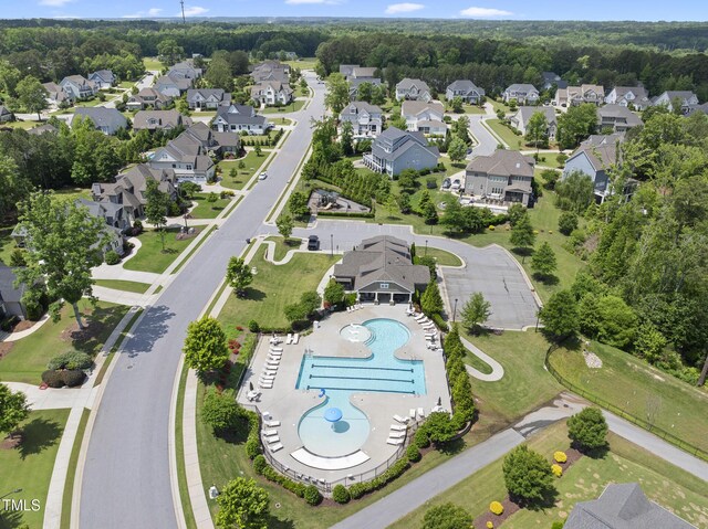 aerial overview of property's location with a pool and nearby suburban area