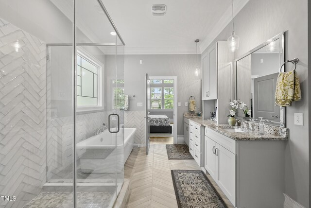 ensuite bathroom featuring a shower stall, vanity, a freestanding bath, and crown molding