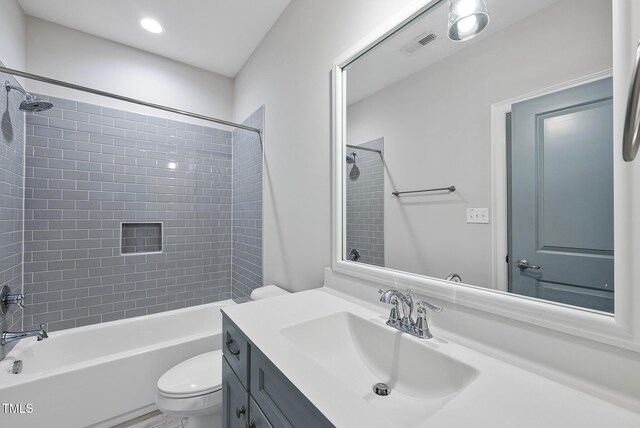 bathroom featuring toilet, vanity, and bathtub / shower combination