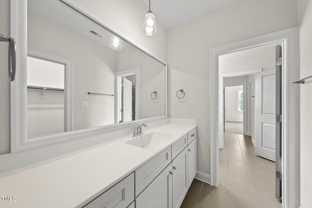 bathroom with vanity, baseboards, and tile patterned floors