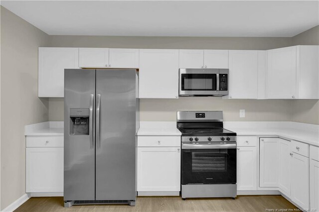 213 Judd St, Fayetteville, NC 28305 - kitchen featuring appliances with stainless steel finishes, light wood-style flooring, white cabinetry, and light countertops
