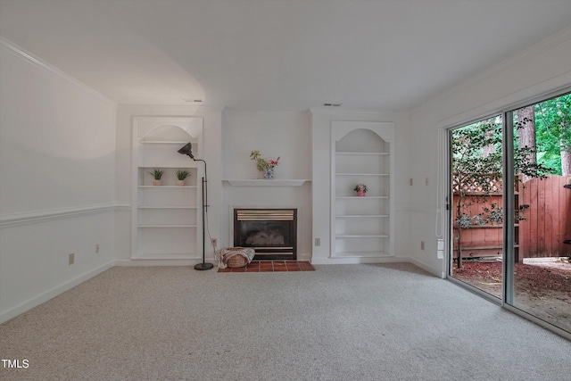 unfurnished living room with built in features, carpet flooring, a fireplace with flush hearth, baseboards, and ornamental molding