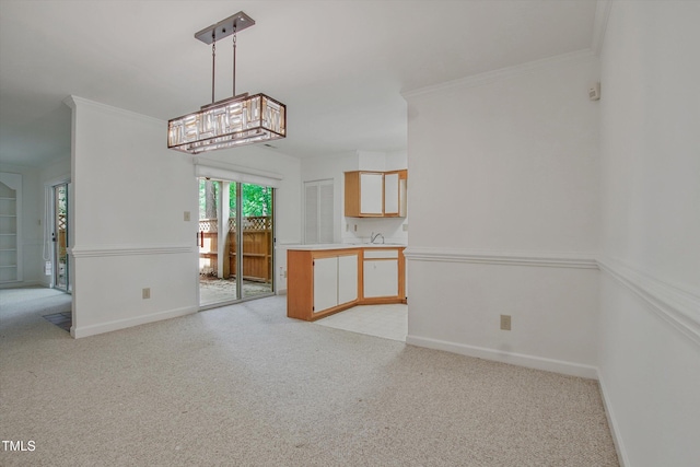 unfurnished dining area featuring light carpet, a sink, baseboards, and ornamental molding