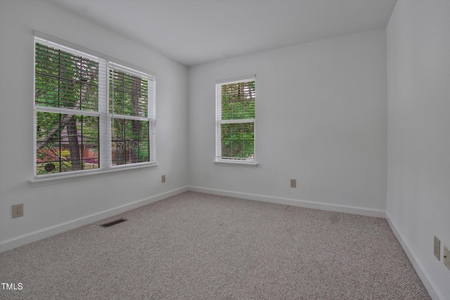carpeted empty room with baseboards