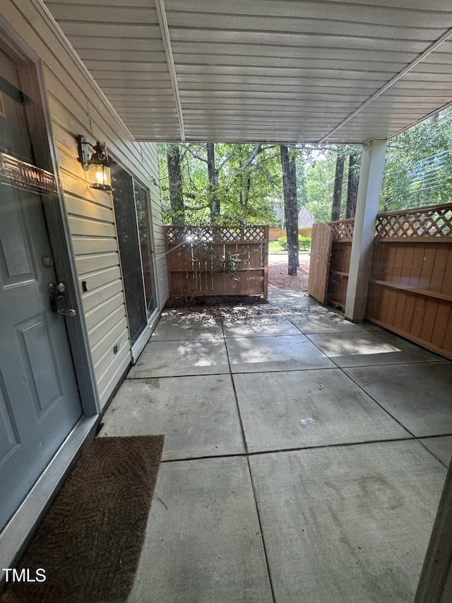 view of patio featuring fence and an attached carport