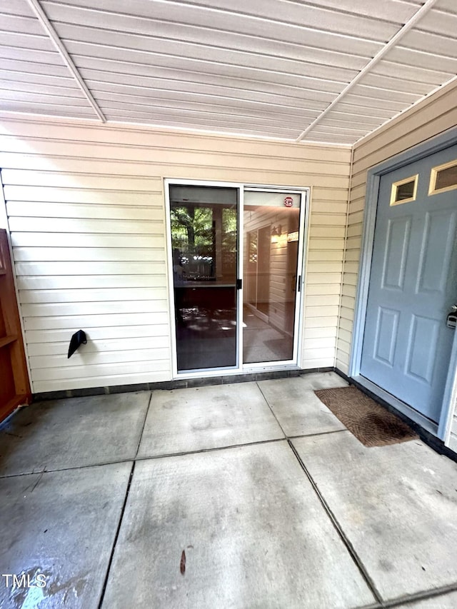 view of exterior entry with a patio