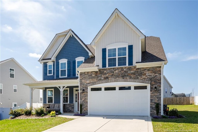 craftsman house featuring stone siding, board and batten siding, a porch, and concrete driveway