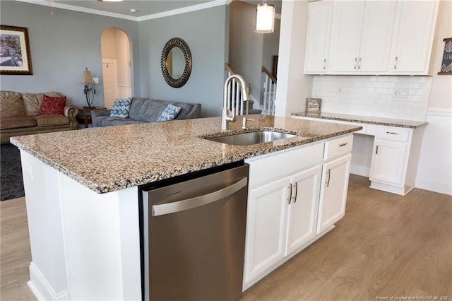 kitchen featuring dishwasher, a sink, open floor plan, light wood-style floors, and crown molding