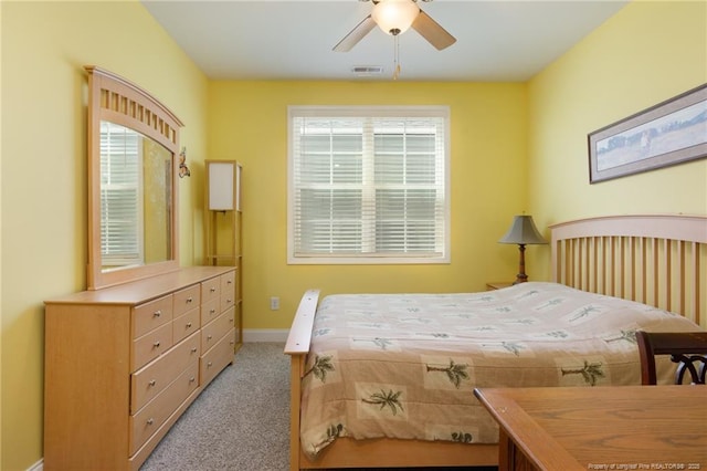 bedroom featuring light carpet, multiple windows, baseboards, and ceiling fan