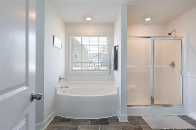 full bath with a shower stall, a garden tub, and baseboards