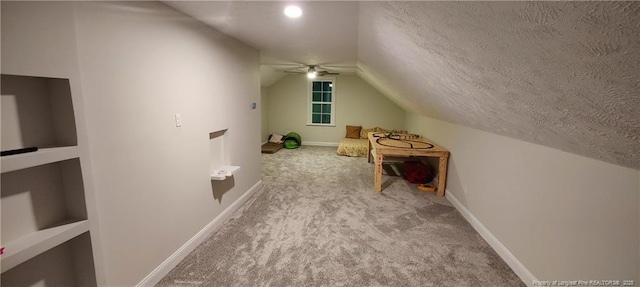 bonus room featuring vaulted ceiling, carpet flooring, a textured ceiling, and baseboards