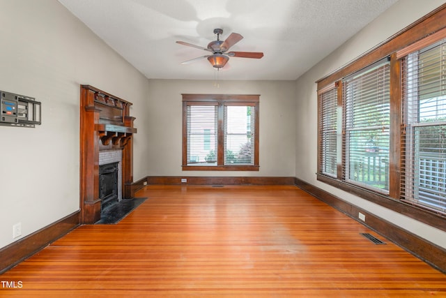104 E Wilson St, Mebane, NC 27302 - unfurnished living room featuring baseboards, light wood finished floors, plenty of natural light, and a ceiling fan