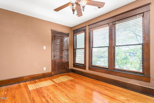 104 E Wilson St, Mebane, NC 27302 - spare room featuring baseboards, wood finished floors, plenty of natural light, and a ceiling fan