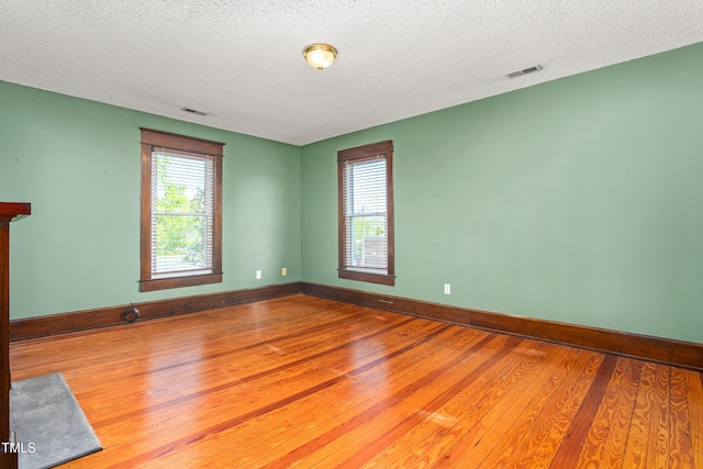 104 E Wilson St, Mebane, NC 27302 - spare room with wood finished floors, plenty of natural light, baseboards, and a textured ceiling