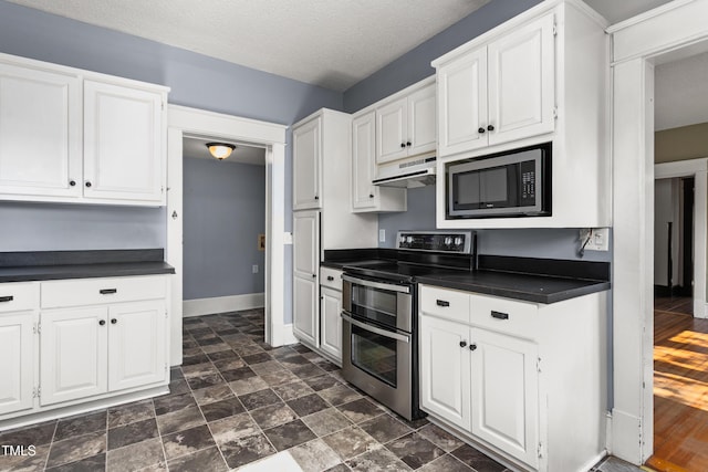 104 E Wilson St, Mebane, NC 27302 - kitchen featuring appliances with stainless steel finishes, dark countertops, under cabinet range hood, white cabinetry, and a textured ceiling