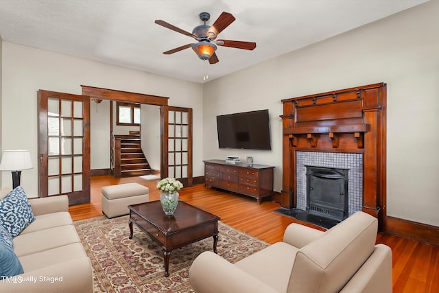 104 E Wilson St, Mebane, NC 27302 - living area featuring wood finished floors, baseboards, a ceiling fan, and a tile fireplace