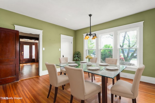 104 E Wilson St, Mebane, NC 27302 - dining area featuring light wood-type flooring, baseboards, and a chandelier