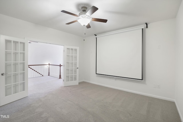 empty room featuring carpet flooring, baseboards, a ceiling fan, and french doors
