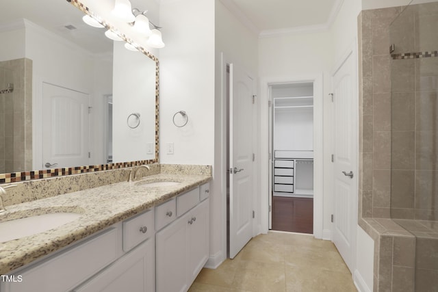 full bathroom featuring a tile shower, ornamental molding, a sink, and double vanity