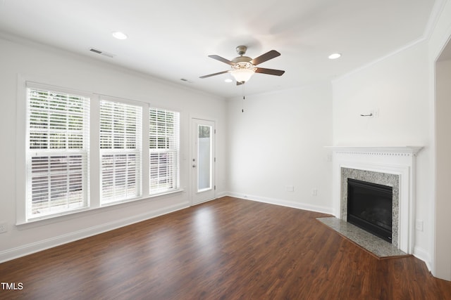 unfurnished living room with a ceiling fan, visible vents, dark wood-type flooring, and a healthy amount of sunlight