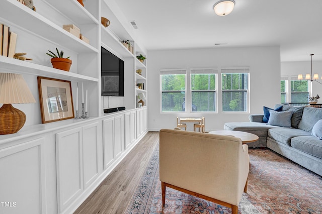 1501 Addison Lake St, Fuquay Varina, NC 27526 - living room with light wood-style floors, visible vents, built in features, and an inviting chandelier