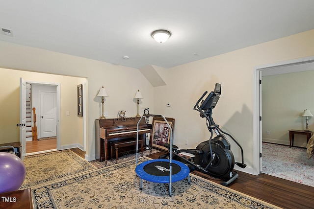 workout room featuring visible vents, wood finished floors, and baseboards