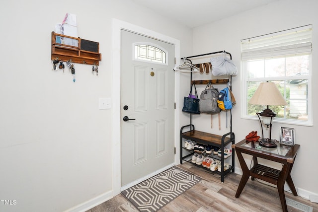 mudroom with light wood finished floors and baseboards