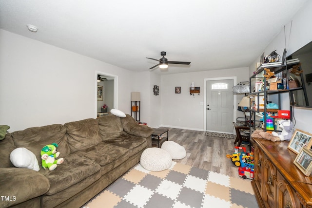 living room with baseboards, wood finished floors, and a ceiling fan