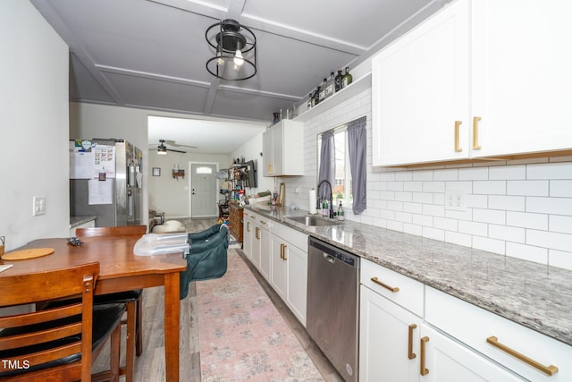 kitchen featuring a sink, tasteful backsplash, light wood-style flooring, white cabinets, and appliances with stainless steel finishes