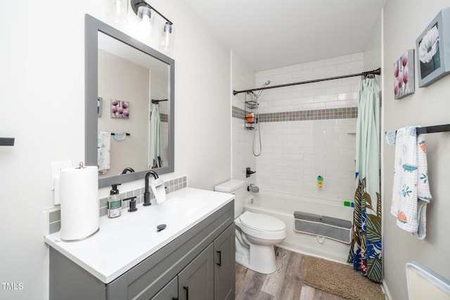 bathroom with shower / bath combo with shower curtain, wood finished floors, toilet, and vanity