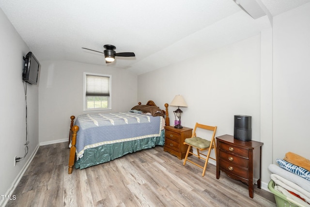 bedroom with baseboards, wood finished floors, a ceiling fan, and vaulted ceiling
