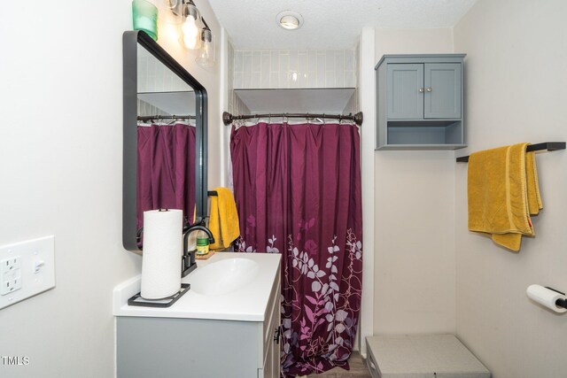 bathroom with curtained shower and vanity