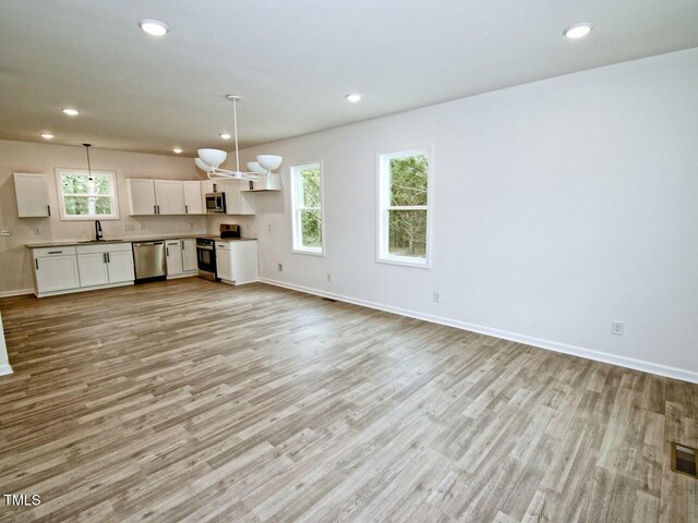 48 S Grace Way, Henderson, NC 27537 - kitchen featuring stainless steel appliances, light wood-style flooring, a sink, baseboards, and white cabinetry