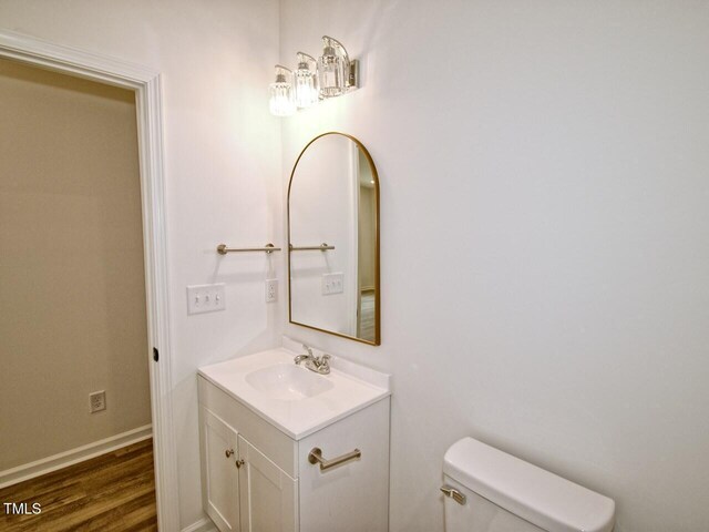 48 S Grace Way, Henderson, NC 27537 - bathroom with baseboards, wood finished floors, toilet, and vanity