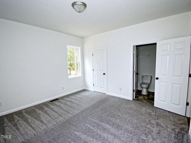 48 S Grace Way, Henderson, NC 27537 - unfurnished bedroom with visible vents, carpet flooring, baseboards, and connected bathroom