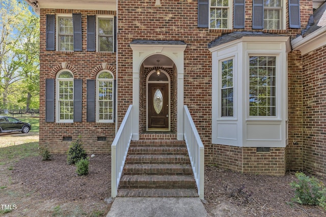 doorway to property featuring crawl space and brick siding