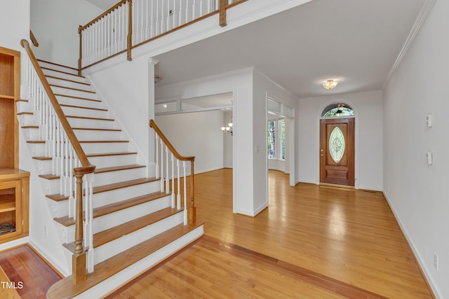 entrance foyer with stairway, baseboards, and wood finished floors
