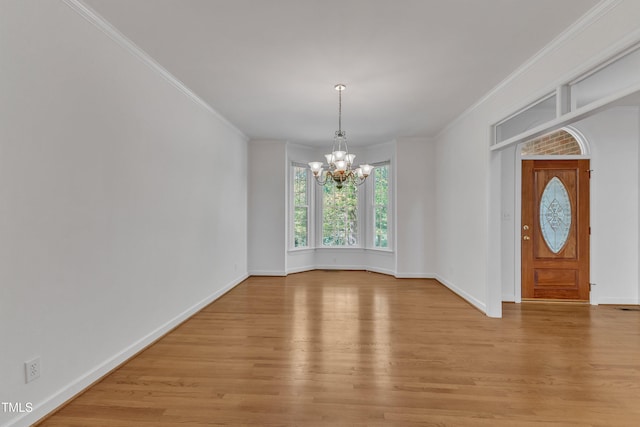 unfurnished dining area with baseboards, ornamental molding, a chandelier, and light wood-type flooring