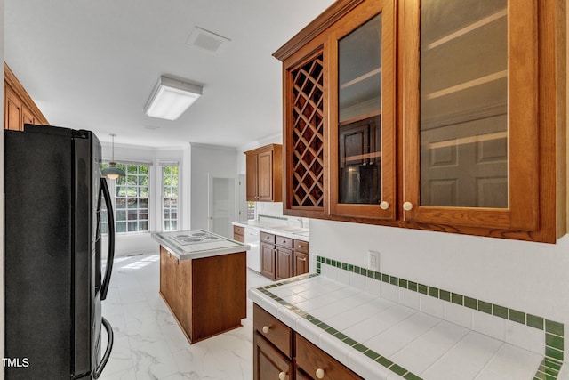kitchen featuring glass insert cabinets, white appliances, a kitchen island, and marble finish floor
