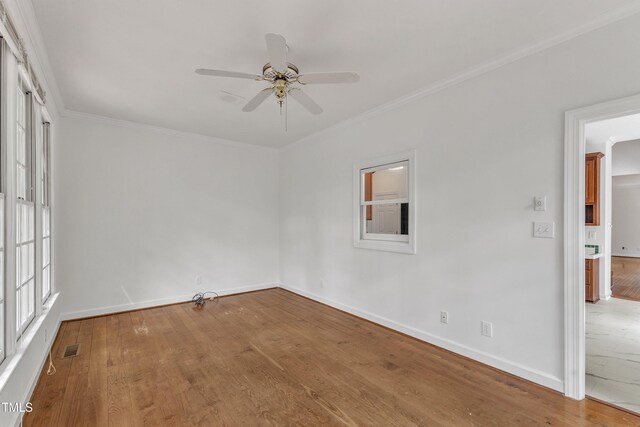 spare room with wood finished floors, visible vents, baseboards, and ceiling fan