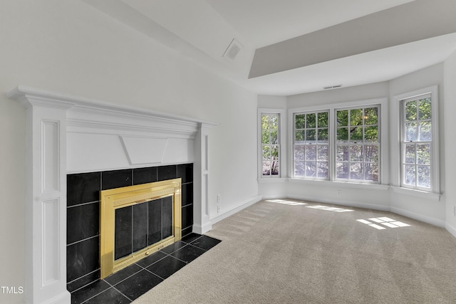 unfurnished living room featuring dark carpet, baseboards, visible vents, and a tiled fireplace