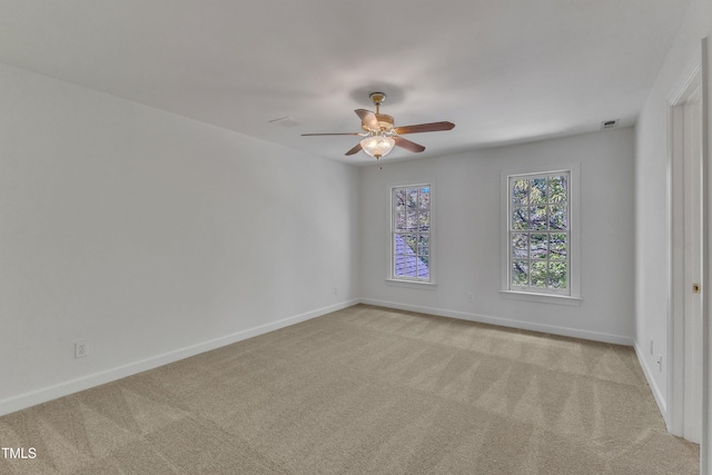spare room with baseboards and light colored carpet