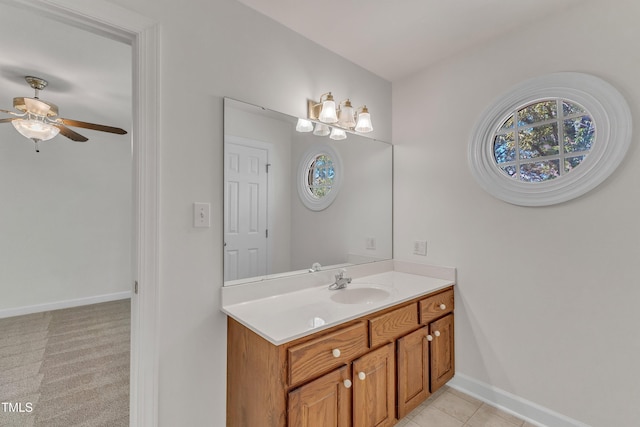 bathroom with baseboards, a healthy amount of sunlight, a ceiling fan, and vanity